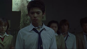 Movie still from “Battle Royale” (2000), directed by Kinji Fukasaku – A young man in a white dress shirt and a tie; Close Up shot, Low angle
