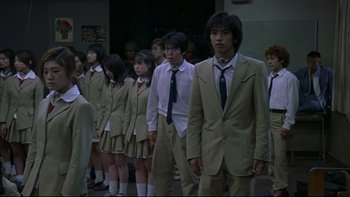 Movie still from “Battle Royale” (2000), directed by Kinji Fukasaku – A group of young people standing next to each other; Medium shot, Low angle