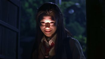 Movie still from “Battle Royale” (2000), directed by Kinji Fukasaku – A young woman with long black hair wearing a red tie; Close Up shot, Low angle