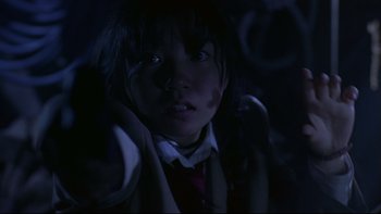 Movie still from “Battle Royale” (2000), directed by Kinji Fukasaku – A young girl in a car seat at night in the dark; Close Up shot, Low angle