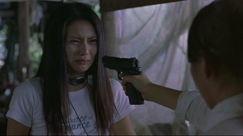 Movie still from “Battle Royale” (2000), directed by Kinji Fukasaku – A woman is holding a gun up to her face; Close Up shot, Over the shoulder angle