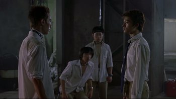 Movie still from “Battle Royale” (2000), directed by Kinji Fukasaku – A group of young men standing next to each other; Medium shot, Low angle