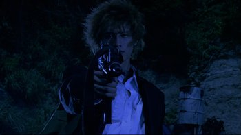 Movie still from “Battle Royale” (2000), directed by Kinji Fukasaku – A man holding a video camera in the dark; Close Up shot, Low angle