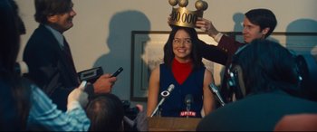 Movie still from “Battle of the Sexes” (2017), directed by Valerie Faris – A woman is smiling while holding a crown on her head; Medium shot, Over the shoulder angle