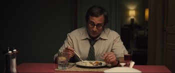 Movie still from “Battle of the Sexes” (2017), directed by Valerie Faris – A man sitting at a dinner table with a plate of food; Medium shot, Over the shoulder angle