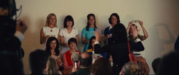 Movie still from “Battle of the Sexes” (2017), directed by Valerie Faris – A group of women standing next to each other on a stage; Medium shot, Over the shoulder angle