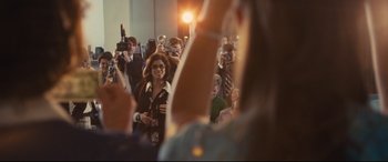Movie still from “Battle of the Sexes” (2017), directed by Valerie Faris – A group of people taking pictures in a crowd; Medium shot, Over the shoulder angle
