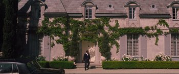 Movie still from “Battle of the Sexes” (2017), directed by Valerie Faris – A man standing in front of a building with vines growing all over it; Wide shot, Low angle