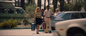 Movie still from “Battle of the Sexes” (2017), directed by Valerie Faris – A man and a woman walking down the street with suitcases; Wide shot, Over the shoulder angle