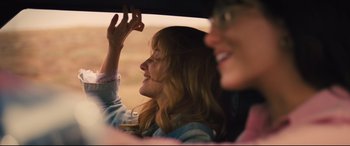 Movie still from “Battle of the Sexes” (2017), directed by Valerie Faris – Two women in a car , one of which is holding her hand up to the sky; Close Up shot, Over the shoulder angle