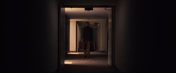 Movie still from “Battle of the Sexes” (2017), directed by Valerie Faris – A man walking down a hall way with a suitcase; Wide shot, Low angle