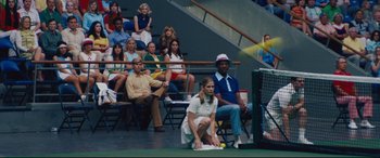 Movie still from “Battle of the Sexes” (2017), directed by Valerie Faris – A woman kneeling down on a tennis court holding a racquet; Wide shot, Over the shoulder angle