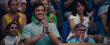 Movie still from “Battle of the Sexes” (2017), directed by Valerie Faris – A man clapping his hands in front of a group of people; Medium shot, Low angle