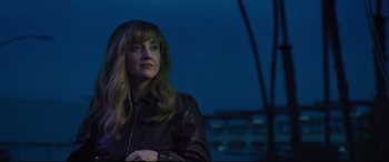 Movie still from “Battle of the Sexes” (2017), directed by Valerie Faris – A woman in a leather jacket looking out a window at night; Medium shot, Low angle