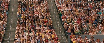 Movie still from “Battle of the Sexes” (2017), directed by Valerie Faris – A crowd of people sitting in a stadium watching a game; Extreme Wide shot, High angle
