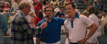 Movie still from “Battle of the Sexes” (2017), directed by Valerie Faris – Two men standing next to each other while one of them is holding a microphone; Medium shot, Over the shoulder angle