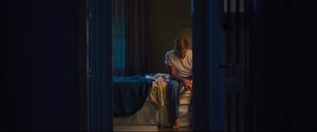 Movie still from “Battle of the Sexes” (2017), directed by Valerie Faris – A man sitting on a bed in a room; Wide shot, Low angle