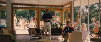 Movie still from “Battle of the Sexes” (2017), directed by Valerie Faris – Two people in a living room , one of them holding a wii controller; Wide shot, Over the shoulder angle