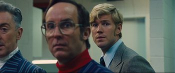 Movie still from “Battle of the Sexes” (2017), directed by Valerie Faris – A man and a man in a suit looking at the camera; Close Up shot, Over the shoulder angle