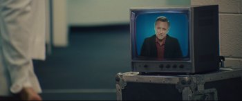 Movie still from “Battle of the Sexes” (2017), directed by Valerie Faris – A television with a picture of a man on it; Close Up shot, Low angle