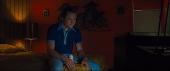 Movie still from “Battle of the Sexes” (2017), directed by Valerie Faris – A man sitting on a bed in a room; Medium shot, Over the shoulder angle