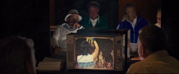 Movie still from “Battle of the Sexes” (2017), directed by Valerie Faris – A television with a picture of a woman on it; Medium shot, Over the shoulder angle