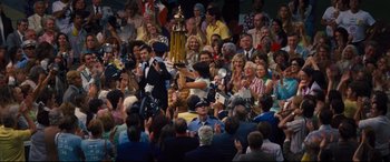 Movie still from “Battle of the Sexes” (2017), directed by Valerie Faris – A crowd of people are gathered in a stadium; Wide shot, High angle