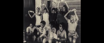 Movie still from “Battle of the Sexes” (2017), directed by Valerie Faris – A group of young men and women posing for a picture; Medium shot, Low angle