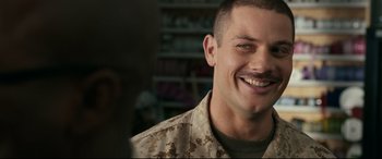 Movie still from “Battle Los Angeles” (2011), directed by Jonathan Liebesman – A man in a military uniform smiling for the camera; Close Up shot, Over the shoulder angle