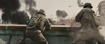 Movie still from “Battle Los Angeles” (2011), directed by Jonathan Liebesman – A soldier in fatigues and a backpack is looking out over a wall; Wide shot, Low angle