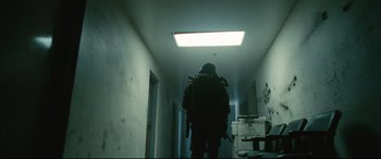 Movie still from “Battle Los Angeles” (2011), directed by Jonathan Liebesman – A person walking down a hallway with a backpack on; Wide shot, Low angle