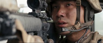 Movie still from “Battle Los Angeles” (2011), directed by Jonathan Liebesman – A soldier is holding a rifle while looking at the camera; Close Up shot, Low angle