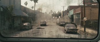 Movie still from “Battle Los Angeles” (2011), directed by Jonathan Liebesman – Cars driving down a street with smoke billowing out of the windows; Extreme Wide shot, High angle