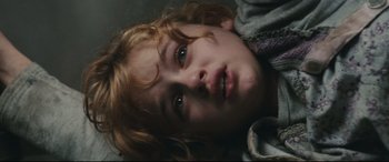 Movie still from “Battle Los Angeles” (2011), directed by Jonathan Liebesman – A young child laying on the ground looking at the camera; Close Up shot, Overhead angle