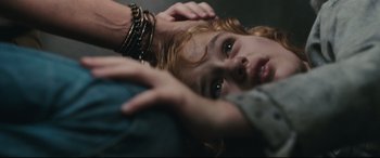 Movie still from “Battle Los Angeles” (2011), directed by Jonathan Liebesman – A young woman is laying on the ground with her hands on her head; Close Up shot, Overhead angle