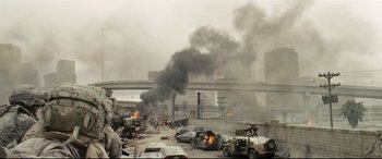 Movie still from “Battle Los Angeles” (2011), directed by Jonathan Liebesman – A street with cars burning in the middle of the road; Extreme Wide shot, Low angle