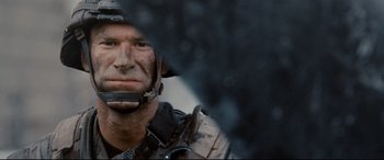 Movie still from “Battle Los Angeles” (2011), directed by Jonathan Liebesman – A man with a helmet on is looking at the camera; Close Up shot, Over the shoulder angle