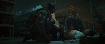 Movie still from “Battle Los Angeles” (2011), directed by Jonathan Liebesman – A group of people sitting around a table; Medium shot, Low angle