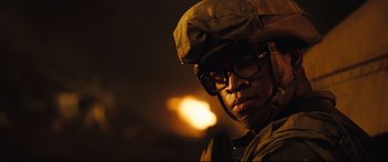 Movie still from “Battle Los Angeles” (2011), directed by Jonathan Liebesman – A man wearing glasses and a hat is standing in the dark; Close Up shot, Low angle