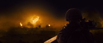 Movie still from “Battle Los Angeles” (2011), directed by Jonathan Liebesman – A soldier standing on top of a building at night; Wide shot, Over the shoulder angle