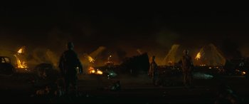Movie still from “Battle Los Angeles” (2011), directed by Jonathan Liebesman – A man standing in front of a burning car at night; Extreme Wide shot, High angle