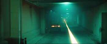 Movie still from “Battle Los Angeles” (2011), directed by Jonathan Liebesman – A car is parked in a parking garage with green lights; Extreme Wide shot, Low angle