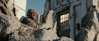 Movie still from “Battle Los Angeles” (2011), directed by Jonathan Liebesman – A man standing in front of a building that has been demolished; Medium shot, Low angle