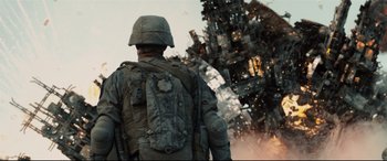 Movie still from “Battle Los Angeles” (2011), directed by Jonathan Liebesman – A man in a military uniform walking away from an exploding building; Wide shot, Low angle