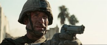 Movie still from “Battle Los Angeles” (2011), directed by Jonathan Liebesman – A person holding a gun in his hand; Close Up shot, Over the shoulder angle