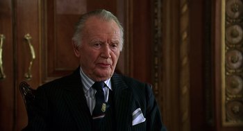 Movie still from “Bean” (1997), directed by Mel Smith – An older man wearing a suit and tie; Close Up shot, Low angle