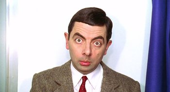 Movie still from “Bean” (1997), directed by Mel Smith – A person wearing a suit and tie; Close Up shot, Low angle