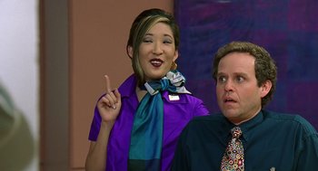 Movie still from “Bean” (1997), directed by Mel Smith – A man and a woman in purple and blue outfits; Close Up shot, Over the shoulder angle