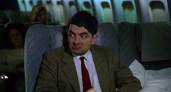 Movie still from “Bean” (1997), directed by Mel Smith – A person sitting on a chair; Close Up shot, High angle