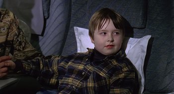 Movie still from “Bean” (1997), directed by Mel Smith – A young boy laying in a bed with a blanket; Close Up shot, High angle